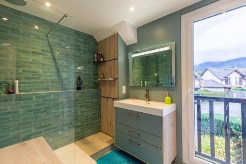 a bathroom with a sink and a shower with a window at Maison mitoyenne proche lac annecy in Annecy-le-Vieux