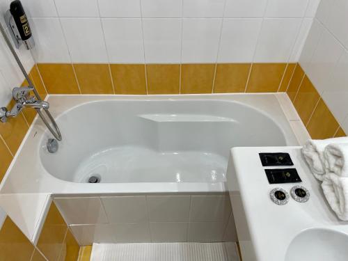a white bath tub in a bathroom with a sink at Hotel Royal in Prague