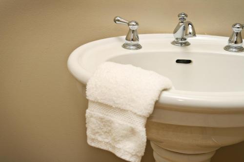 a white bathroom sink with a towel hanging from it at Balch Hotel in Dufur