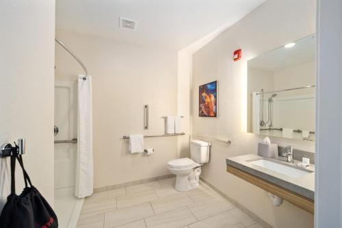 ein Badezimmer mit einem WC, einem Waschbecken und einem Spiegel in der Unterkunft Candlewood Suites - Ocala I-75, an IHG Hotel in Ocala