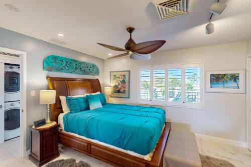a bedroom with a bed and a ceiling fan at Tropical Elegance Golf Course Penthouse in Waikoloa