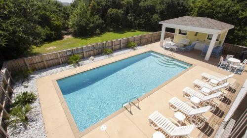 an overhead view of a swimming pool with chairs and a gazebo at Oceanside, Pool with Poolside Bar, Rec Room, Hot Tub, Sun Decks, SS8, Group Therapy in Southern Shores