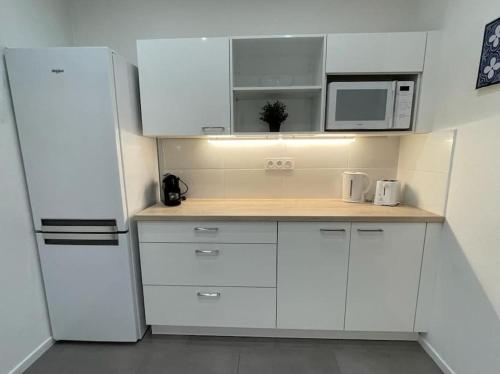 une cuisine avec des armoires blanches et un réfrigérateur blanc dans l'établissement Strasbourg Contades Clemenceau : ), à Strasbourg