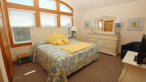 a bedroom with a teddy bear laying on a bed at Oceanside, Pool with Poolside Bar, Rec Room, Hot Tub, Sun Decks, SS8, Group Therapy in Southern Shores