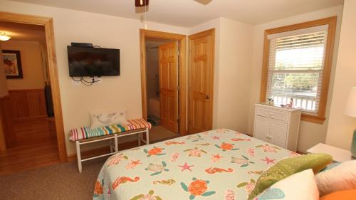 a bedroom with a bed and a television in it at Oceanside, Pool with Poolside Bar, Rec Room, Hot Tub, Sun Decks, SS8, Group Therapy in Southern Shores