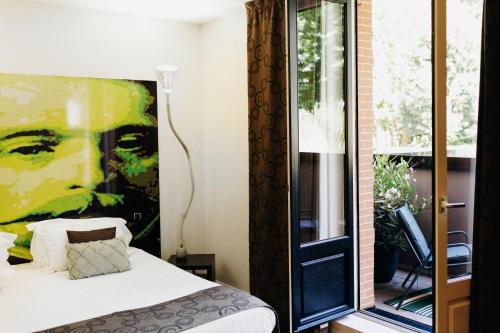 une chambre avec un lit et une peinture d'un homme dans l'établissement Maison Decoret - Relais & Châteaux, à Vichy