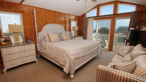 une chambre avec un lit, un canapé et une fenêtre dans l'établissement Semi-Oceanfront, Close to Beach, Rec Room, Pool, Hot Tub!, SS135, Sea-Esta, à Southern Shores