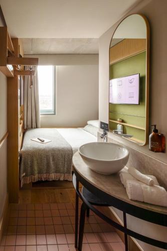 a bathroom with a sink and a bed with a mirror at Wren Urban Nest in Dublin