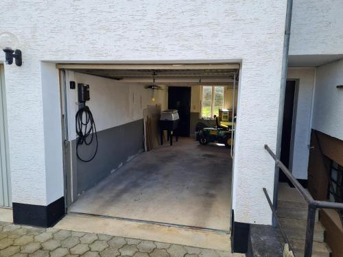 an open garage door with a driveway at Ferienwohnung Dörnbergblick Klinge in Calden
