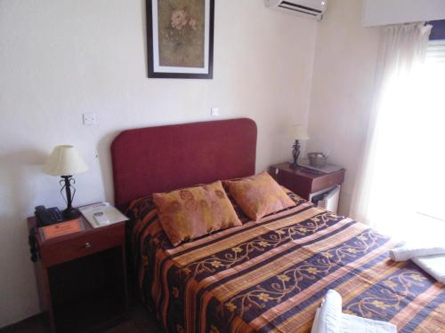 a hotel room with a bed and two night stands at Hotel City Piriápolis in Piriápolis
