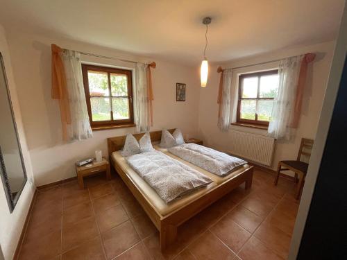 ein Schlafzimmer mit einem Bett und zwei Fenstern in der Unterkunft Ferienwohnung Ott in Weißenburg in Bayern