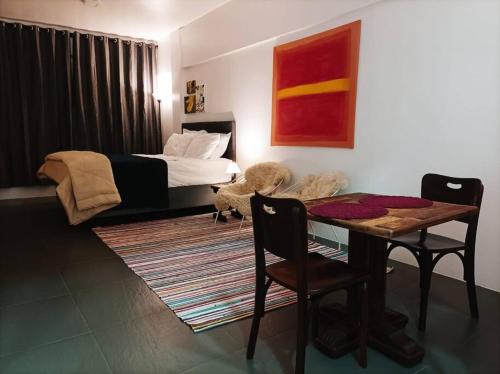 um quarto com uma cama, uma mesa e cadeiras em Bebel 1108 em Florianópolis