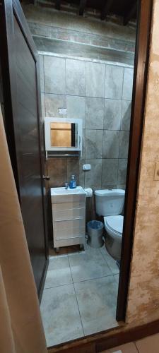 a small bathroom with a toilet and a sink at Hot Chipilin in Antigua Guatemala