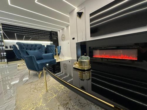 a living room with a fireplace and blue chairs at APARTMANI JERKOVIĆ - DUNAV 1 - Premium in Vukovar