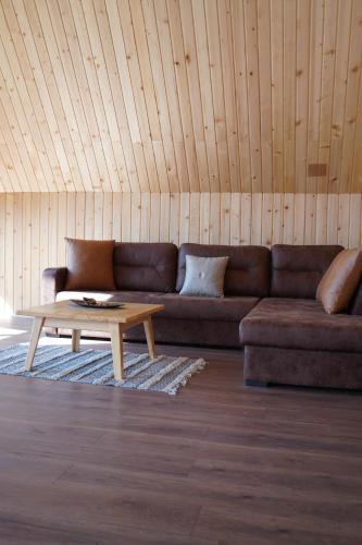 a living room with a brown couch and a coffee table at Villa standard n'Bjeshkë in Dragash