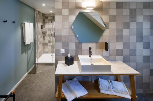 a bathroom with a sink and a shower at Hotel Münzgasse - Self Check-in in Lucerne