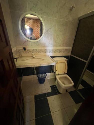 a man taking a picture of a bathroom with a toilet and sink at Casa na serra de mulungu in Mulungu