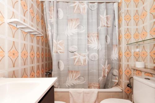 y baño con cortina de ducha y aseo. en Apartment Doble-4CD, en Lloret de Mar