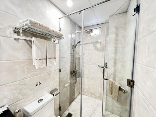 a bathroom with a toilet and a glass shower at Sao Mai Hotel in Ho Chi Minh City