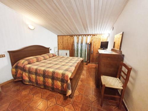 um quarto com uma cama e uma secretária com um computador em La casa in montagna em Villalago