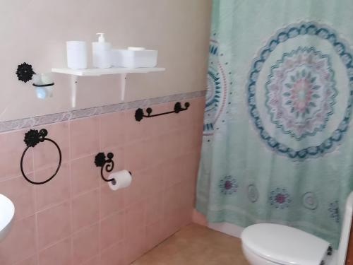 y baño con cortina de ducha y aseo. en Casa vacacional en zona céntrica en Conil, en Conil de la Frontera