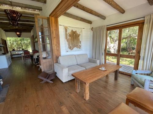 a living room with a white couch and a table at Chacra La Esencia, casa de campo in El Eden