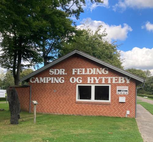 a sign on the side of a brick building at Sdr. Felding camping & hytteby in Sønder Felding