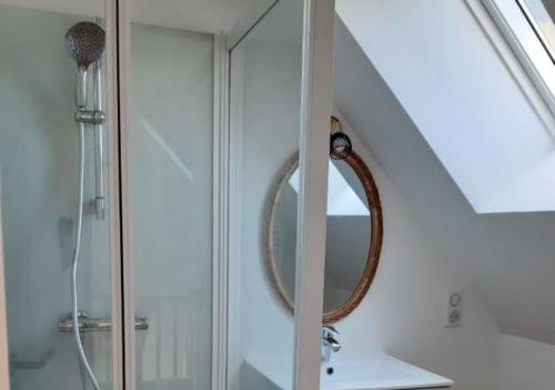 een badkamer met een douche en een spiegel bij Les Chaumines, St Cast le Guildo in Saint-Cast-le-Guildo