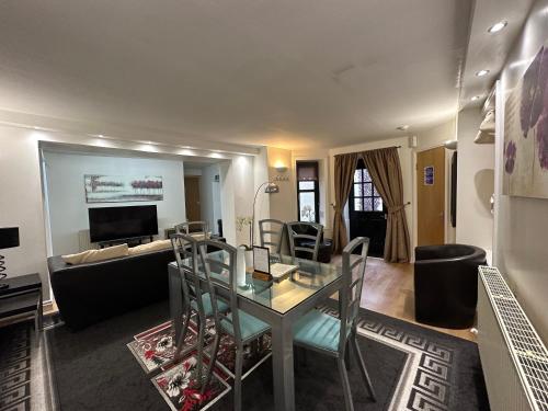 a living room with a glass table and chairs at The Carlton's Holiday Suites in Bridlington