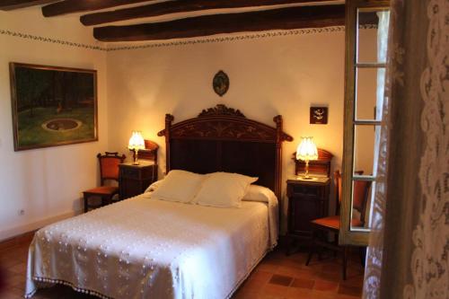ein Schlafzimmer mit einem Bett, zwei Tischen und einem Fenster in der Unterkunft Cal Marques in Santa Oliva