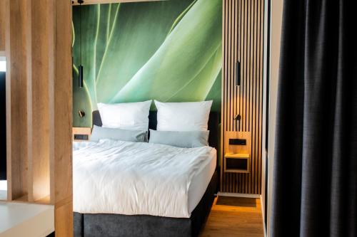 a bedroom with a bed with a green wall at Boardinghouse Hense in Lingen