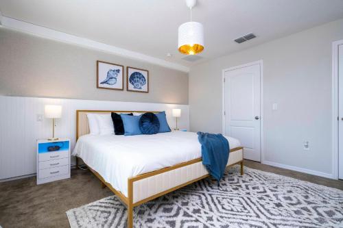 une chambre avec un grand lit avec des oreillers bleus dans l'établissement Amazing 3BD and 25BH 8 miles from Disney, à Kissimmee