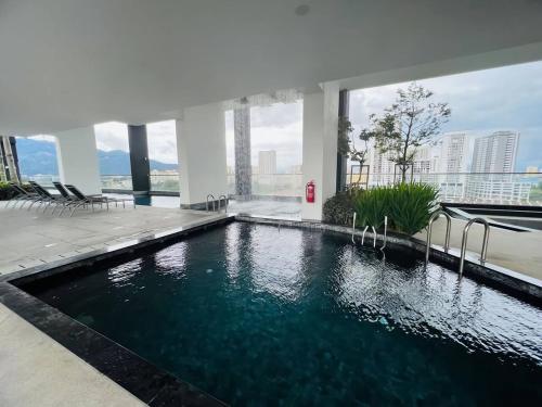 a swimming pool in the middle of a building at Urban Suites by PerfectSweetHome Cozy Style in Jelutong
