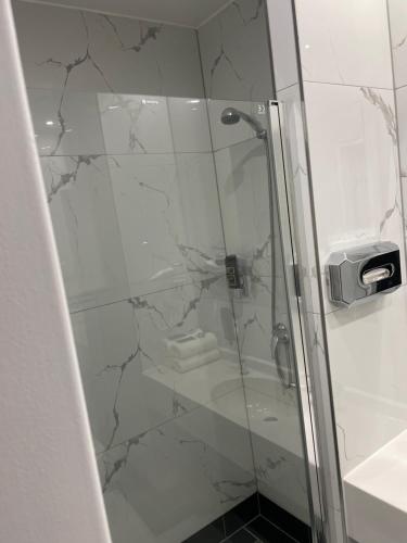 W łazience znajduje się prysznic ze szklanymi drzwiami. w obiekcie Hotel Royal w Pradze
