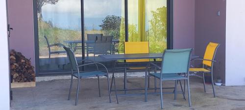 una mesa y sillas frente a una ventana en hébergement touristique, meublé des neiges, en Le Tampon