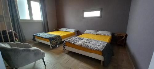 Zimmer mit 3 Betten und einem Fenster in der Unterkunft hébergement touristique, meublé des neiges in Le Tampon