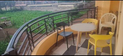 een balkon met stoelen en een tafel op een leuning bij Airbnb in Mwea town 
