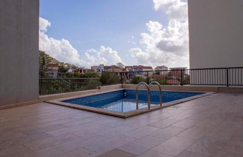 a swimming pool in the middle of a patio with a balcony at Yellow Studio Retreat Tivat in Tivat