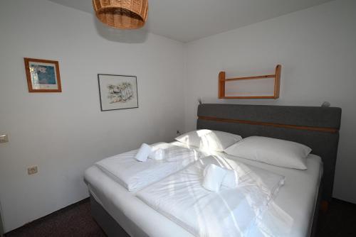 卡普倫的住宿－Apartment Haus 1 Top 11 - by Four Seasons Apartments，一间卧室配有带白色床单和枕头的床。