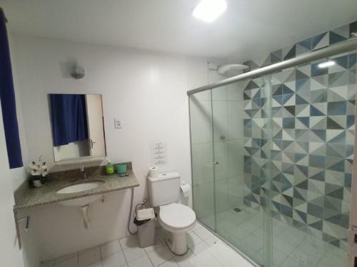 a bathroom with a toilet and a sink and a shower at Pousada Estrela do Mar in Salvador