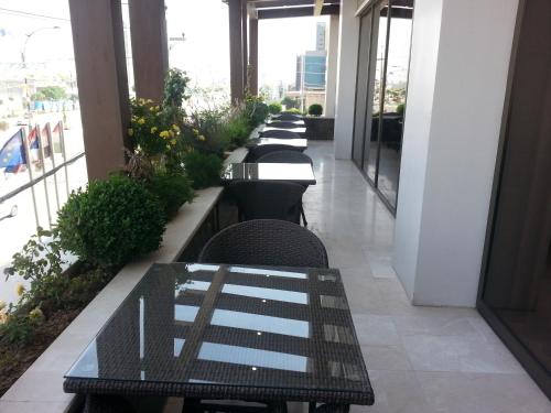 a row of tables and chairs in a building at Hotel Hilen De Ville in Erbil