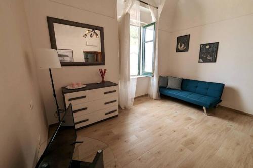 a living room with a blue couch and a mirror at Love House sul mare in Cetara