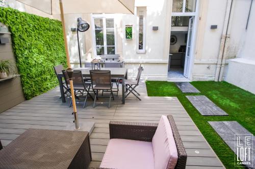 un patio avec une table, des chaises et de l'herbe dans l'établissement Le loft Cannes, à Cannes