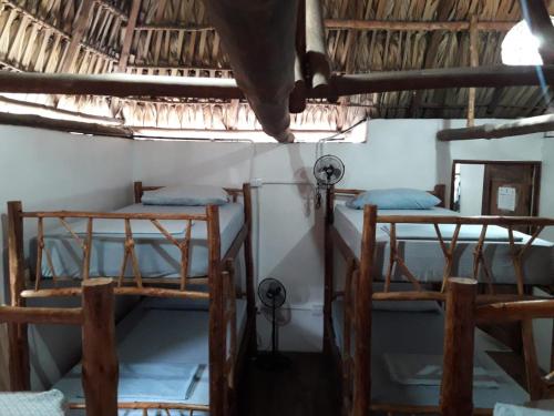 a room with three bunk beds in a house at Backpackers Hostel in Sipacate