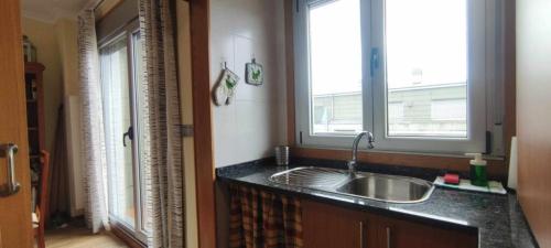 cocina con fregadero y ventana en Apartamento Punta Balea, en Cangas de Morrazo