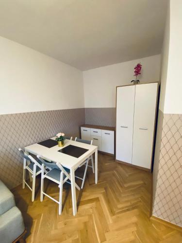 a kitchen with a white table and a white cabinet at ClickTheFlat Miła Center Apart Rooms in Warsaw