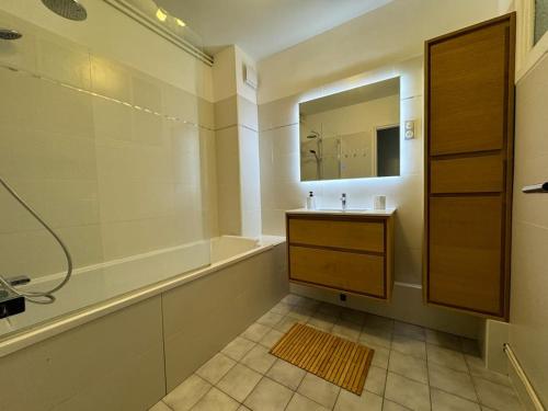 uma casa de banho com um lavatório, uma banheira e um espelho. em Le Tiki de Notre-Dame - duplex vue Cathédrale em Boulogne-sur-Mer