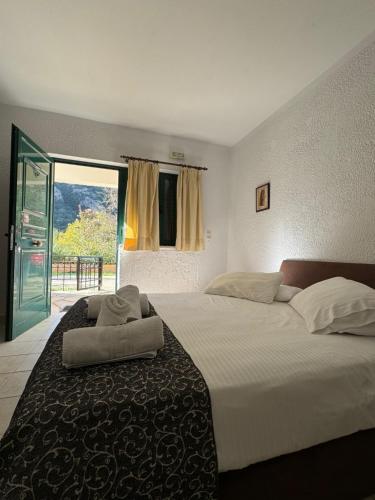 a bedroom with a large bed with a large window at Muntenia Inn Apartments and Suites in Kalavrita