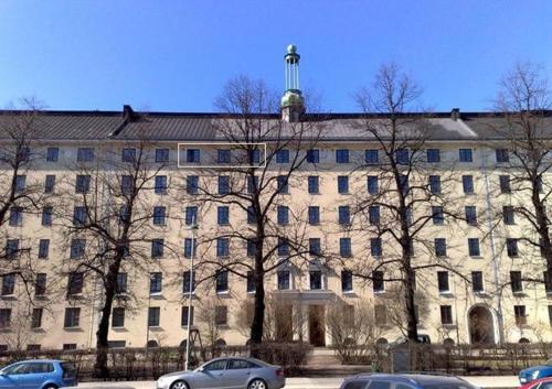 a large building with cars parked in front of it at Urheilukatu20 Olympiastadion Ooppera, 4 makuupaikkaa in Helsinki