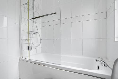 a white bathroom with a tub and a shower at Emma's Central House & Parking in Nottingham